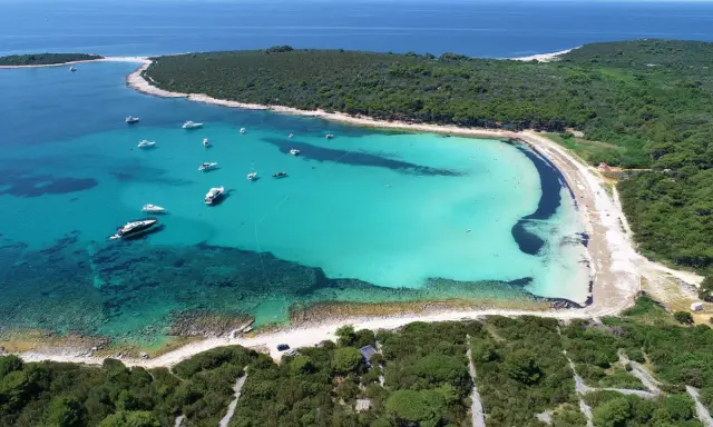 Rajska zatoka z turkusową wodą i łodziami, jedna z najpiękniejszych plaż w Chorwacji.