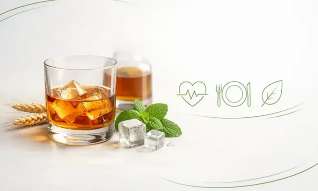 Szklanka whisky z lodem, butelka, kłosy zboża i mięta. Wyobraź sobie, że to pomieszczenie, w którym dojrzewa whisky.