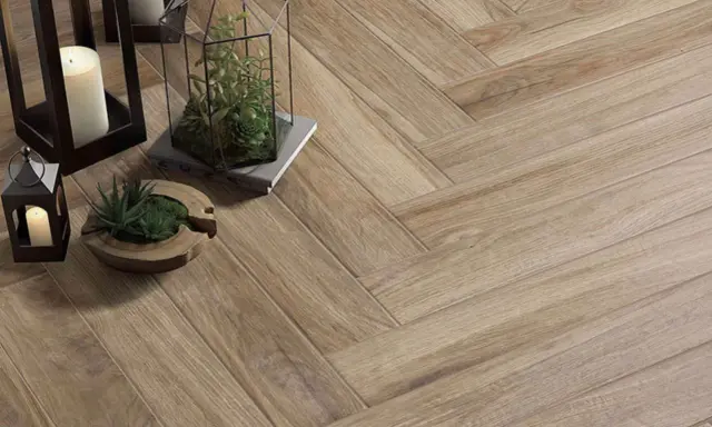 Detalles de cómo colocar azulejos en espiga, con velas y plantas decorativas sobre el suelo de madera.