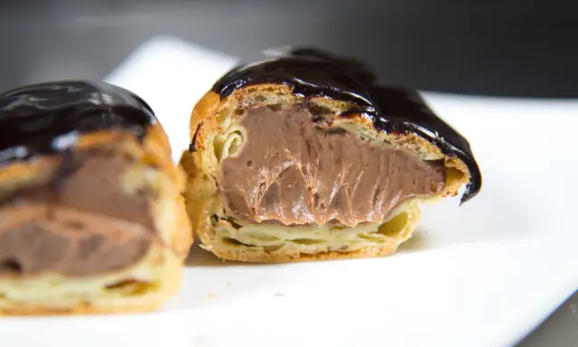 Éclairs généreusement garnis de crème pâtissière chocolat, nappés d'un glaçage brillant. Un délice gourmand.
