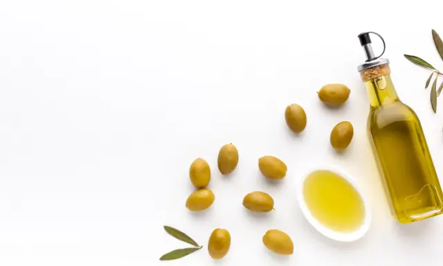 Botella de aceite de oliva virgen extra y aceitunas verdes. El mejor aceite de oliva para tomar crudo, con un sabor fresco y puro.