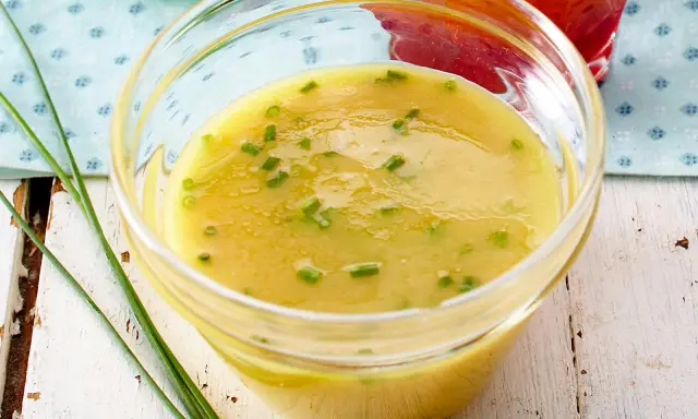 Cremige Honig-Senf-Sauce mit Schnittlauch in einer Glasschale, bereit zum Verfeinern von Salaten.