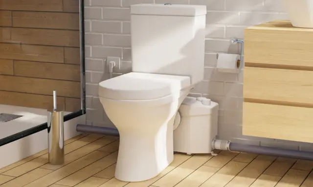 Moderno baño con inodoro triturador, lavabo de madera y ducha. Opiniones positivas sobre su eficiencia.