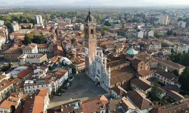 Vista aerea della Duomo di Monza, con la sua facciata a strisce bianche e nere. Si vede il campanile e il centro storico, che mostra dove si trova Monza.