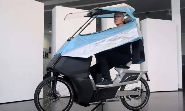 Mann auf einem E-Bike mit Dach, das an ein Auto erinnert.