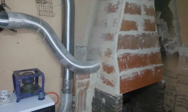 Instalación de tubos flexibles para estufa de leña, conectando a la chimenea de ladrillo.