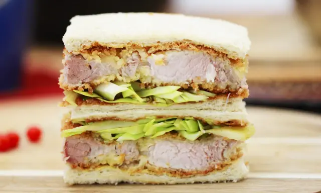 Ein saftiges Katsu Sando mit knusprigem Schnitzel, frischem Kohl und weichem Brot. Ein Genuss für jeden Feinschmecker!