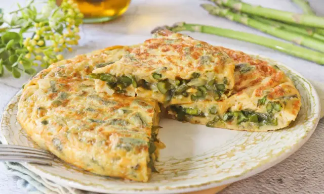 Tortilla de esparragos jugosa y dorada, con espárragos frescos y tiernos en su interior. Un plato delicioso y saludable.