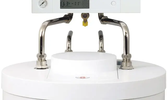 Nowoczesny piec gazowy kondensacyjny z cyfrowym wyświetlaczem i manometrem. Widoczne przyłącza hydrauliczne.