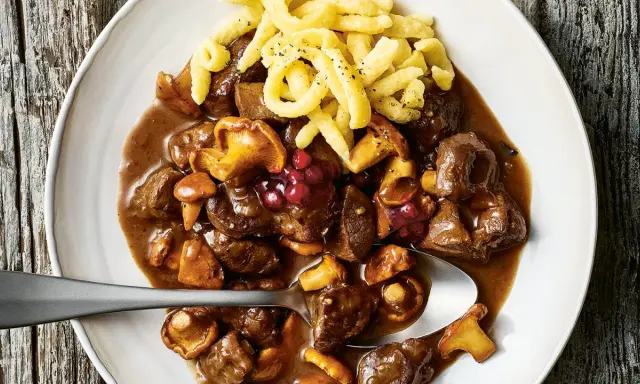 Herzhaftes Rehgulasch mit Rotwein, Pilzen und Preiselbeeren, serviert mit Spätzle. Ein köstliches Rehgulasch Rezept.