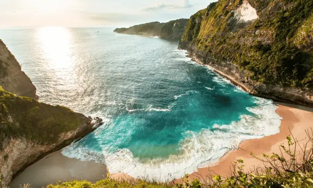 Rajska zatoka z turkusową wodą i piaszczystą plażą, otoczona klifami. Idealne miejsce, by zobaczyć Bali.