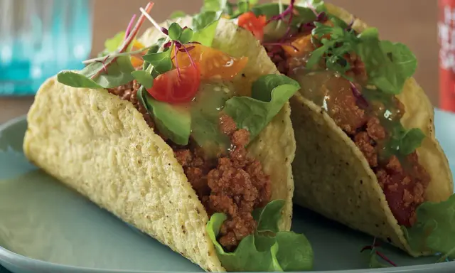 Två läckra vegetariska tacos med avokado, tomat och grönsaker. Perfekt för en snabb och smakrik måltid.