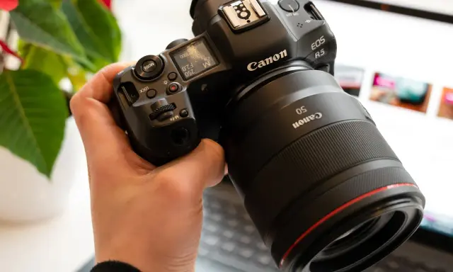 Dłoń trzyma aparat Canon R5 z obiektywem 50mm. Trwa test możliwości sprzętu.