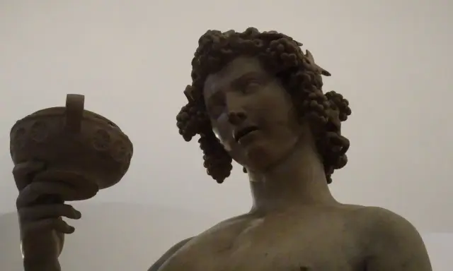 Bacchus, jeune dieu du vin, couronné de grappes, tient une coupe. Une œuvre d'art inspirée par Michel-Ange.
