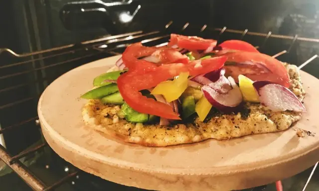 Pizza na kamieniu w piekarniku, z pomidorami, papryką i cebulą. Po pieczeniu dowiedz się, jak umyć kamień do pizzy.
