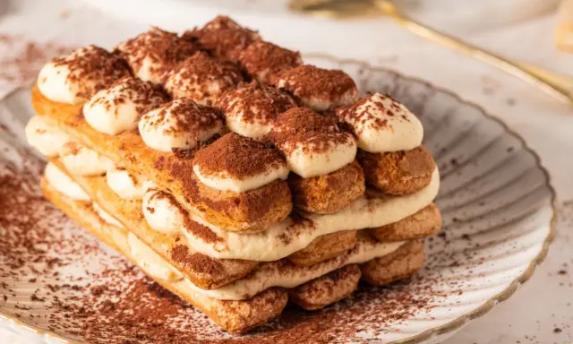 Pyszne tiramisu bez jajek, warstwowo ułożone biszkopty i krem, posypane kakao. Idealne na deser.