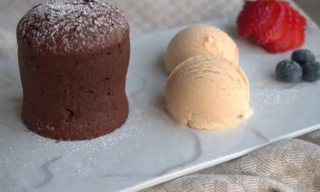 Delicioso coulant de avellana con helado cremoso, fresa y arándanos.