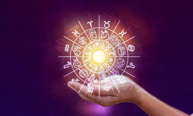 Obracający się znak zodiaku nad dłonią, zapowiadający horoskop na weekend.