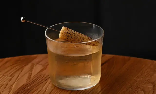 Szklanka z drinkiem i kawałkiem kukurydzy, intrygująca zapowiedź tego, jak smakuje brandy.