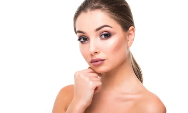 Portrait d'une jeune femme au maquillage sophistiqué, mettant en valeur ses magnifiques sourcils à la libanaise.