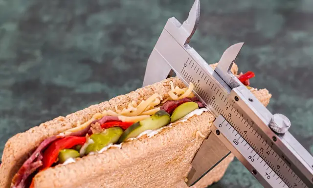 Kanapka z serem, mięsem i warzywami, mierzona suwmiarką. Wygląda na to, że ma duzo kcal.