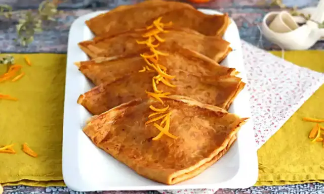 Färdigstekta crêpes, vikta och prydda med apelsinskal. Ett perfekt crepes recept för en härlig frukost eller dessert.