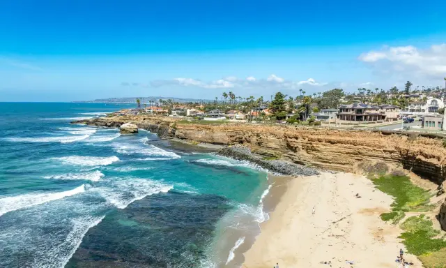 Traumhafte Küste in San Diego mit türkisfarbenem Wasser, sandigem Strand und Villen auf den Klippen.