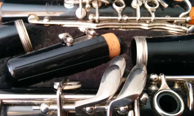 Détail d'une clarinette démontée, prête pour apprendre à jouer de cet instrument. Les clés argentées brillent.