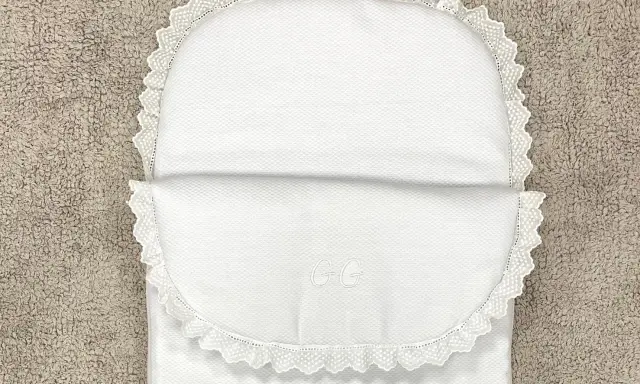 Patrón saco bebé capazo blanco con encaje y iniciales GG bordadas. Perfecto para un dulce descanso.