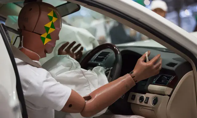 Maniquí en un coche, con el airbag desplegado. El airbag, entre otras funciones, protege de impactos.
