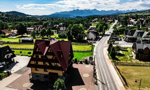 Malownicze tatrzańskie miejscowości z charakterystyczną architekturą i górami w tle.