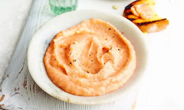Cremiger, rosafarbener Dip mit Pfeffer bestreut, perfekt als schneller Dip zu Kartoffeln. Daneben ein geröstetes Brot mit Lachs.