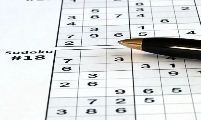 Zapisane sudoku dla seniorów, z numerami #17 i #18. Długopis czeka na rozwiązanie.