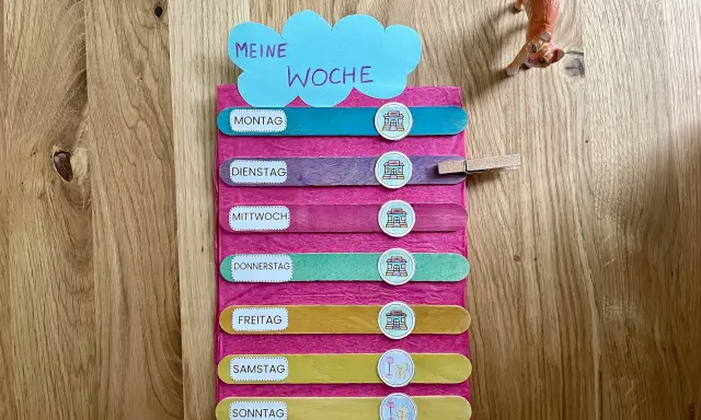Montessori-Tafel zum Wochentage lernen. Bunte Holzstäbchen mit den Tagen der Woche und Symbolen.