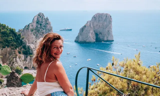 Donna sorridente con vista sui Faraglioni di Capri. Un ricordo indimenticabile da Castiglione.