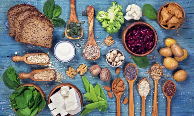 Różnorodne produkty bogate w białko dla wegetarian: tofu, soczewica, fasola, orzechy, nasiona, płatki owsiane, ryż, chleb pełnoziarnisty, jogurt, szpinak, brokuły, kalafior.