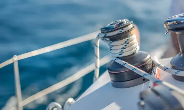 Un treuil de bateau avec une corde enroulée, un élément essentiel du vocabulaire de marin pour naviguer sur l'eau bleue.