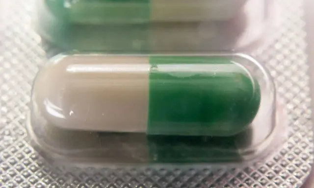 Dwie kapsułki leku Seronil 10 mg w blistrze. Jedna kapsułka jest biało-zielona, druga zielono-biała.