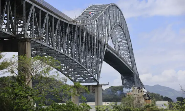 El **Puente de las Américas** cruza el Canal de Panamá, una imponente estructura de acero gris con un arco majestuoso.