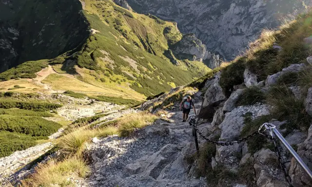 Turysta pokonuje kamienisty szlak z łańcuchami. Czy szlak na Giewont jest trudny? Ten odcinek wymaga ostrożności i dobrej kondycji.