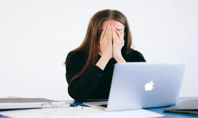 Donna disperata davanti al PC, vittima di un reato revenge porn.
