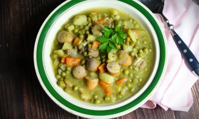 Herzhaftes Erbsensuppe Rezept mit Würstchen, Kartoffeln und Karotten, garniert mit Petersilie. Ein Klassiker für kalte Tage.