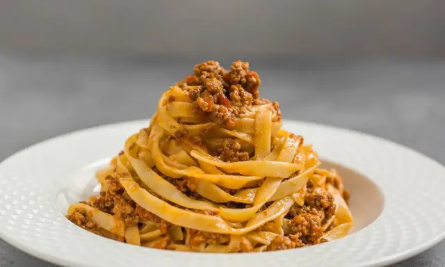 Porcja tagliatelle z bogatym sosem mięsnym, klasyczne spaghetti bolognese w nowej odsłonie.