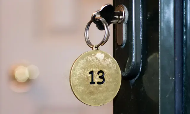 Klucz z okrągłą zawieszką z numerem 13 włożony do zamka.