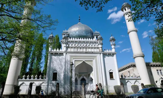 Weiße Moschee mit Kuppel und Minaretten, ein Beispiel für orientalische Architektur, im Sonnenschein.