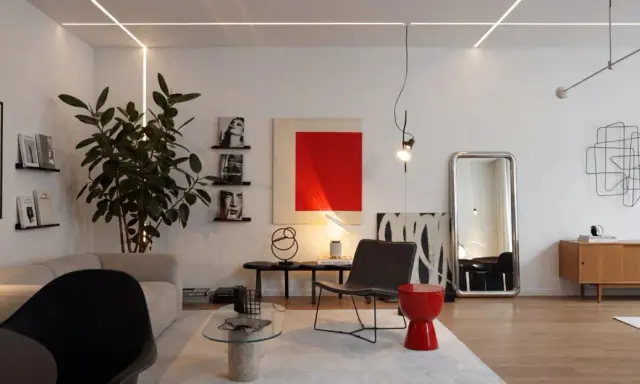 Salotto moderno con divano, poltrona, tavolino in vetro e un tocco di stile bauhaus nell'arredamento.