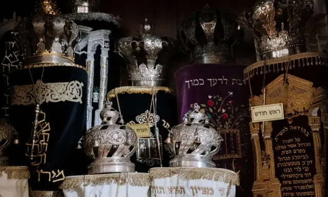 Srebrne korony i ozdobne zwoje Tory, przypominające o królewskiej chwale i mądrości z Psalmu 21.