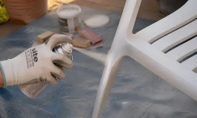 Application d'un apprêt sur une chaise blanche. Le temps de séchage de l'acétone avant peinture est crucial pour une finition parfaite.