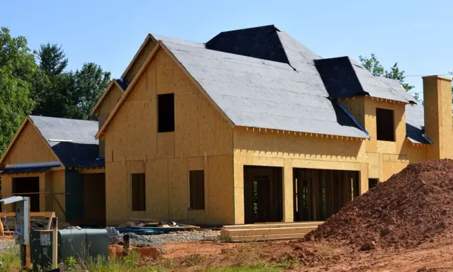 Construction d'une maison en bois, prête à moderniser une maison existante. Le toit est recouvert de feutre, les murs sont en panneaux OSB.