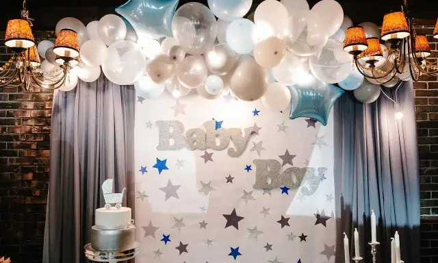 Dekoracja na chrzest święty: balony, gwiazdki, tort i napisy "Baby Boy".